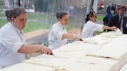 Workers start to apply the vanilla Swiss meringue buttercream frosting.