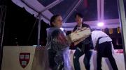 The moment the crowd has been waiting for: Joanne Chang ’91 begins to remove layered sheets from her massive red velvet cake so pieces can be cut and served.