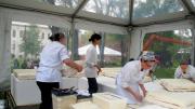 Employees unwrap and arrange the sheets as Flour owner Joanne Chang ’91 looks on.
