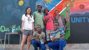 Xue standing in front of the mural that she and her students painted together, an elaborate map of Namibia