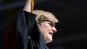 Clayton Spencer hoists the cap that her father, Samuel Reid Spencer, wore as president of Mary Baldwin College and of Davidson College, during her installation ceremony as the eighth president of Bates College. 
