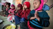 Photograph by Peter Pereira At the crèche, children receive food, education, healthcare, and access to clothing for purchase at low prices. Here, a nondenominational prayer before mealtime. Children on the construction sites come from India's various faiths: Hindu, Muslim, Sikh, and more.