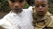 A war-affected girl in Rwanda cares for her younger sibling.