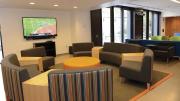 Recent renovations in Old Quincy, now renamed Stone Hall: a new community room with couches, flat-screen TV, a new kitchen, and a below-grade terrace outside the glass doors