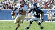 Conner Hempel (14), making his first start at quarterback, threw four touchdown passes as Harvard opened the season with a victory over the University of San Diego. The pursuing defender is end Blake Oliaro. 