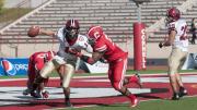 Crimson quarterback Michael Pruneau was almost trapped for a safety by Cornell linebacker Tre’ Minor in the final quarter at Schoellkopf Field. Pruneau escaped, and directed a late drive that gave Harvard a 34-24 victory over the Big Red. At right is tailback Paul Stanton Jr., the game’s top ground-gainer.