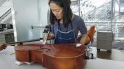 Angela Chang, assistant director and conservator of objects and sculpture, readying a cello for display.