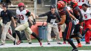 Harvard wide receiver runs up field, away from Princeton defenders.