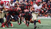 Aidan Borguet of Harvard runs by Princeton's Samuel Wright and Jeremiah Tyler.