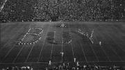 Band in formation spells out "BUY..."