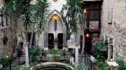 Photo of the cloister courtyard decorated for the holidays with strings of lights and touches of red amid the greenery