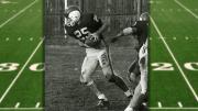 Ric Zimmerman leans forward with football in hand