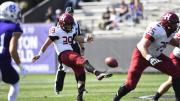 The Harvard punter kicks the football