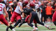 Two Harvard linebackers tackle a Princeton receiver
