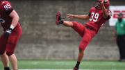 Jon Sot punts a football.