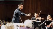 Sam Wu conducts an orchestra