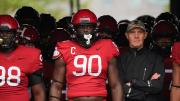 Senior defensive lineman David Madzivanyika, captain and defensive lineman Truman Jones, and coach Tim Murphy get ready to lead the team out of the tunnel before kickoff.