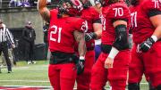 Harvard running back Aidan Borguet celebrates one of his two touchdowns with senior offensive linemen Scott Elliott and Alec Bank.