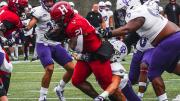  Dragging a Crusader defender, Harvard's Aidan Borguet scores his first of two touchdowns for the day.