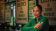 Allison Feaster wearing a green Celtics shirt in front of team championship banners