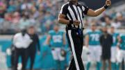 NFL referee Ron Torbert in uniform on the football during a game