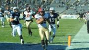 On Harvard’s first series, tailback Paul Stanton Jr. took a handoff from quarterback Conner Hempel, cut to the left sideline, and sprinted 25 yards for a touchdown. Stanton would score three more times in the opening half. Following him into the end zone are Yale defensive backs Robert Ries (34) and Spencer Rymiszewski (17), and Harvard wide receiver Andrew Berg (8). 