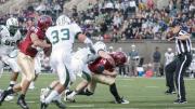 Dragging Dartmouth defensive back Garrett Waggoner with him, quarterback Conner Hempel (14) scored Harvard’s first touchdown on a nine-yard keeper play in the opening quarter. The Harvard blocker is Paul Stanton (29); the Big Green defender is linebacker Michael Runger (33).