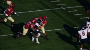 Two Harvard defenders tackle Penn's Maurcus McDaniel