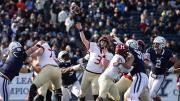 Luke Emge throws the football amidst Yale defenderss