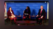 The three speakers are seated on stage at Harvard's JFK Forum.