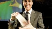 David Kwong shuffles the cards. Behind him, a video gives a closer look at his hands.