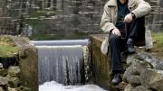 When not dealing with major global water issues, John Briscoe manages this small dam near his home. He holds the hook used to open the sluice gate.