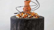 Clay head over wooden pill bottles with wires representing the impact of opioids on human beings