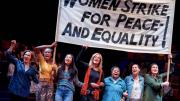 Scene from "Gloria, A Life," showing women marching in solidarity with protest sign