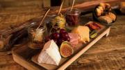 A platter of cheese, cured meats, and fruit
