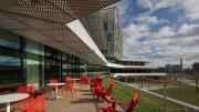 A photo of red chairs and white tables on one of the south-facing terraces afford views of Boston and Cambridge.