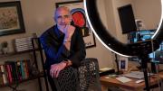 Arthur Brooks stands behind a chair in his office, smiling