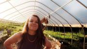 Reid Parsons stands in a greenhouse amid plants