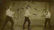 Three men juggle while roller-skating