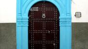 A decorated residential door in the medina in Rabat, Morocco, 2005. The "hand of Fatima" trident at upper left wards off evil and brings luck.