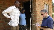 University Provost Steven Hyman, who visited Uganda in 2009 to learn about SHIP and other projects in Mbarara, signs the guest book at Nshemereirwe's house as Musinguzi looks on.
