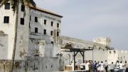 The entrance to St. George's Castle in Elmina, bustling with tourists and souvenir hawkers, demonstrates Ghana's role in the slave-tourism industry.