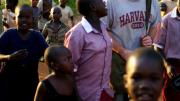 Christopher Higgins ’10 walks through Busia, Uganda, in July with residents of the New Hope orphanage (wearing the crimson-and-white New Hope school uniform) and children from the community.