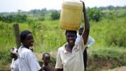 Loice Pamba (right) heads home with her (purified) water, while Everlyne Narocho—the resident responsible for making sure the dispenser stays filled at this site—looks on.