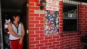 Herrera stands in the doorway of her home.