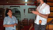 Ana Lamilla, one of the community organizers at the Renca project, talks with Gonzalo Arteaga in the Huertas' living room during a recent tour. Visible in the background is the archway leading into the Huertas' kitchen, which they created by enclosing the backyard. This unit, in its original condition, was identical to Rosa Ortega's; the Huertas finished the walls and ceilings and replaced the staircase.