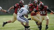 HOT PURSUIT: Defenders Schultz (52), Curtis (91), and Barnes (25) closing in on Yale back Mike McLeod.