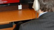 Each cubicle has two monitors that allow study participants to see the other participants (on the right-hand screen) alongside information or a stimulus presented by the experiment leader. Participants can communicate with one another through their headphones.
