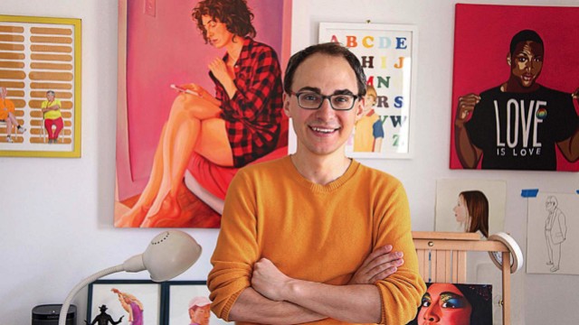 David Andersson standing among his colorful painted portraits