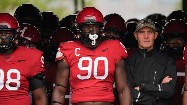 Senior defensive lineman David Madzivanyika, captain and defensive lineman Truman Jones, and coach Tim Murphy get ready to lead the team out of the tunnel before kickoff.